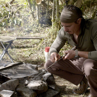 Timothy Alberino sharpening a machete at base camp during an expedition to a lost city in the Andes mountains of Peru.