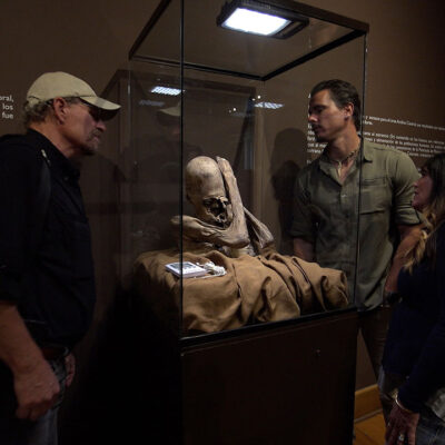 Timothy Alberino, Chase Kloetzke, and L.A. Marzulli, examining an elongated skull mummy in Lima, Peru.